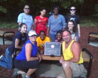 Figure+2%3A+Students+participating+in+a+community+gardening+program+from+Metropolitan+State+University+and+Inver+Hills+Community+College+%28circa+2012%29.+The+bronze+plaque+pictured+is+dedicated+to+the+community+of+Newtown%2C+Connecticut